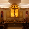 The sanctuary on an elevated floor, with the altar on front and a crucifix at the back. There is an arc above the crucifix, and its pedestal is also the tabernacle. Statues of four saints are on the sides of the crucifix: two on each side. I was not able to approach, but it seems like they are St. Pedro Calungsod, Mary (with crown), St. Joseph, and St. Lorenzo Ruiz.