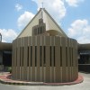 The frontage of Our Lady of Perpetual Help Parish along Jersey St. It has a triangular hat-like brown roof. The small structure with light on a pole on top in front is the new adoration chapel.