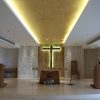 The sanctuary of Chapel of St. Padre Pio in Shangri La EDSA has predominant colors of brown and white. White marbles for the floor and white concrete for the walls except for the brown rectangular recess where the crucifix is mounted. The crucifix is also brown with light coming from its back. The ceiling is white but bisected by brown recess along the middle above the crucifix. In front of the crucifix is the altar, and two lecterns in front and on the sides of the altar. The priest's chair is on the left of the crucifix, and also visible is a small table on the right of the crucifix. The chair, table, altar, and lecterns are all brown. Also visible here is a statue of St. Anthony wearing black robe and carrying baby Jesus on the back of the left lectern.