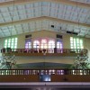 The balconies at the back of San Isidro Labrador Parish; the structure is quite rare: there is one balcony on the second level and a smaller balcony on the third level. There are two chandeliers in front of the smaller balcony and hang over the larger balcony. The balconies are surrounded by colored glass windows.