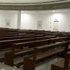 The photograph of the nave of the Our Lady of the Most Holy Rosary Chapel taken sideways at an angle from the central corridor. Several rows of brown wooden seats are seen here. The upper part of the wall has the text of Hail Mary in big white letters on grayish green marble background.