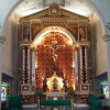 Altar of Sto. Rosario Parish The altar of Sto. Rosario Parish in Pasig shows a crucifix in an arch-like structure with pillars on the left and on the right. There is an angel on top of each of the two pillars. Above the crucifix is a dove enclosed by sun-like ornament and below it is the tabernacle. The color of the crucifix and the surrounding structure is mostly maroon and gold, while the altar is covered with a green cloth.