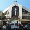 The frontage of Saint Joseph Shrine is yellowish white. The ground floor is separated from the second story by a concrete ceiling. The middle of the ceiling has a triangular part that is raised from the rest and supported by pillars. In front of this part are the words: St. Joseph Shrine Diocese of Cubao. Two small statues of angels are on this triangular part, one on each side; there are also larger statues of angels underneath, one beside each pillar. The second floor is house-like in shape, making the center the highest part of the church. On the middle of the second floor, a large statue of Saint Joseph standing on a sphere and holding baby Jesus is attached. On the sides are two rows glass windows that are tall and narrow: the ones on the lower rows are rectangular while the ones on the upper rows are trapezoidal, conforming to the shape of the roof. A concrete cross is on the top-center of the roof.